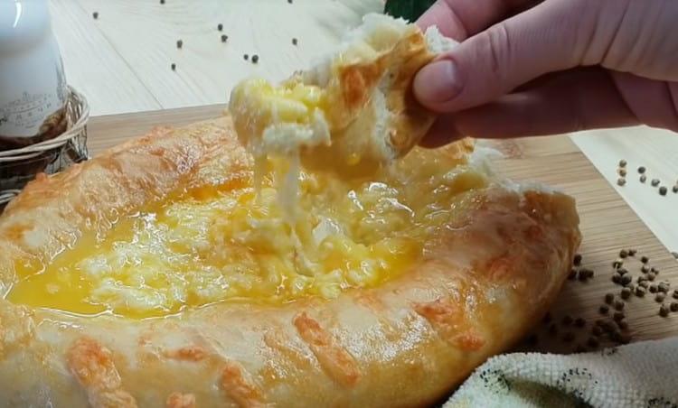 Il Khachapuri in stile Adjarian viene mangiato, mescolando il ripieno con l'uovo e immergendolo in pezzi di pasta.