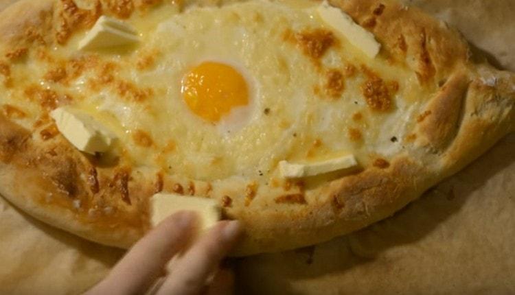 Quando serviamo khachapuri con l'uovo, lo lubrificiamo ancora con un pezzo di olio.