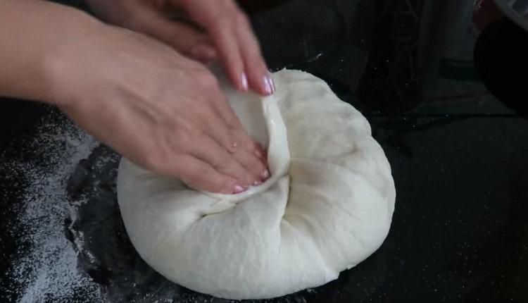 Schiacciamo l'impasto, formiamo il pane rotondo.