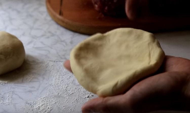 Impastare ogni pallina di pasta in una piccola torta.