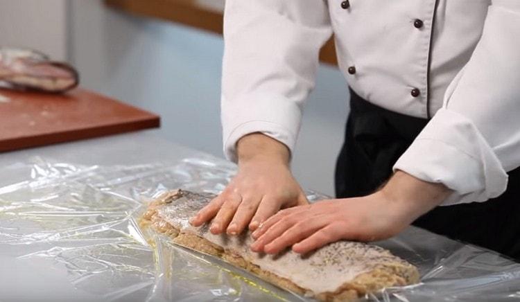 Distribuiamo il luccio su una manica da forno unta con olio d'oliva e ungiamo la pelle con olio.