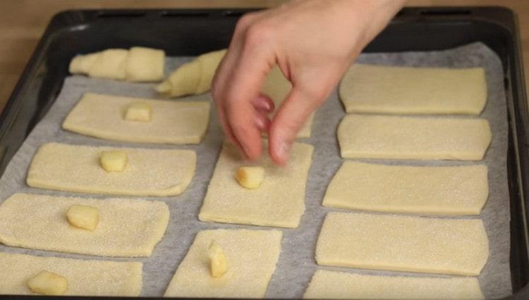 Al centro di ogni pezzo di pasta, stendi un pezzo di mela.