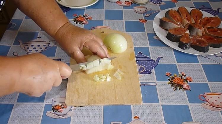 Per cucinare lo stufato di salmone rosa, tagliare la cipolla