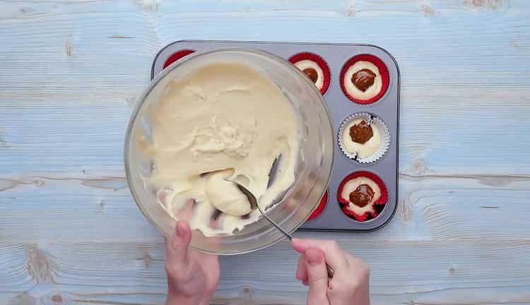 Per preparare cupcake con latte condensato, mettere l'impasto sopra il latte condensato