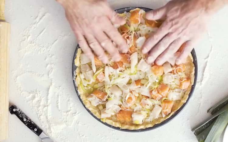 Per preparare la quiche con pesce, metti il ​​ripieno sull'impasto