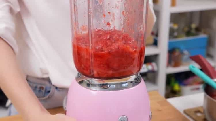 Macina le bacche per preparare la cheesecake alla fragola