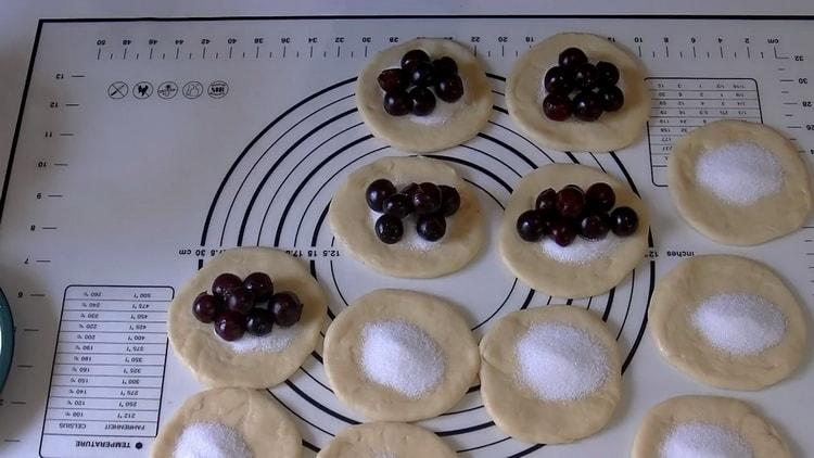 Per fare le torte di ciliegie, metti il ​​ripieno sull'impasto