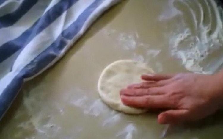 Stendi l'impasto per fare torte con uova e cipolle verdi.