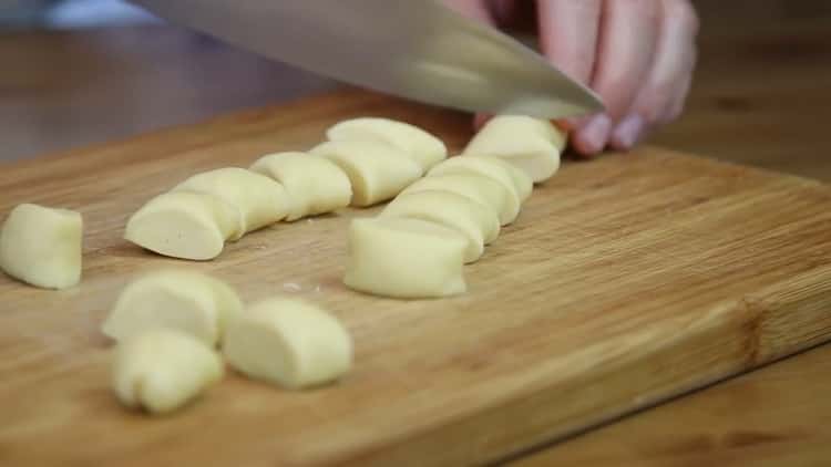 Per fare le ciambelle con latte condensato, tagliare l'impasto