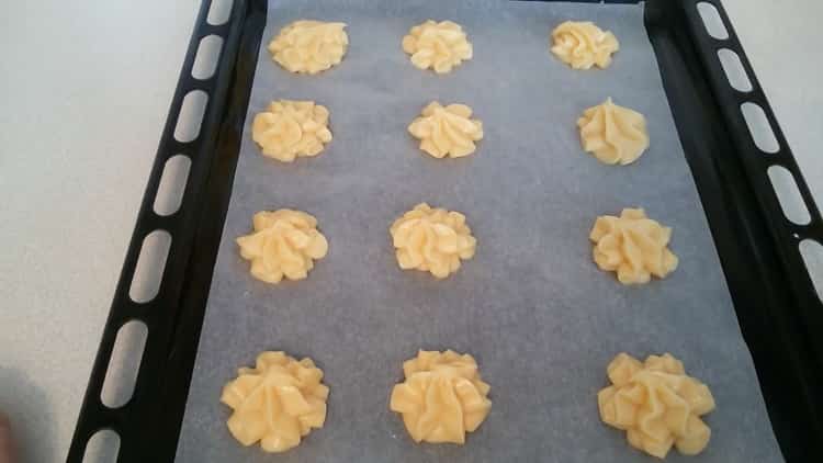 Per preparare i profiteroles con crema pasticcera, mettere l'impasto su una teglia