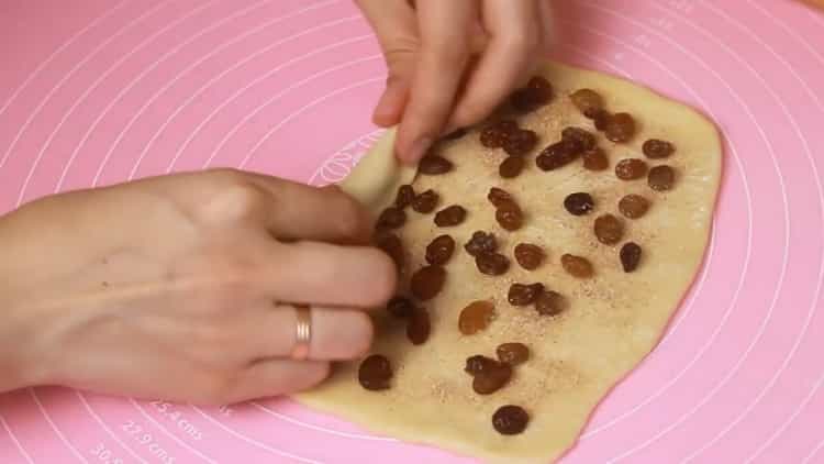 Per preparare i panini, metti l'uvetta sull'impasto