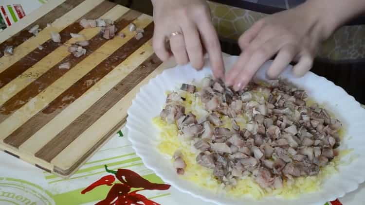 Per cucinare le aringhe sotto una pelliccia, tagliare il pesce