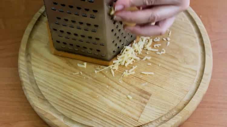 Per cuocere lo sgombro con le verdure al forno, grattugiare il formaggio