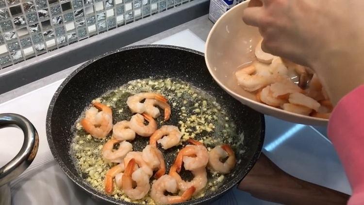 Per preparare gli spaghetti ai gamberi in salsa cremosa, friggere i gamberi