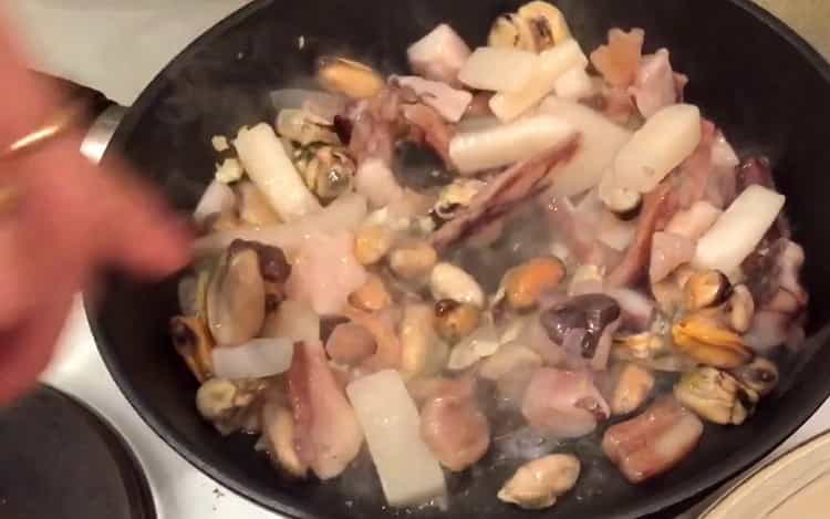 Per mescolare gli spaghetti ai frutti di mare, mescola gli ingredienti.