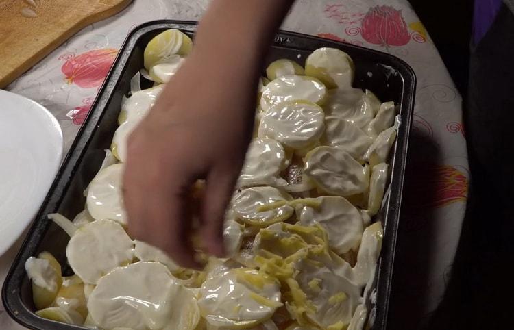 Per preparare il merluzzo con le patate al forno, cospargere le patate con il formaggio