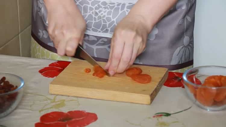 Per preparare le lumache dalla pasta sfoglia, tagliare le albicocche secche