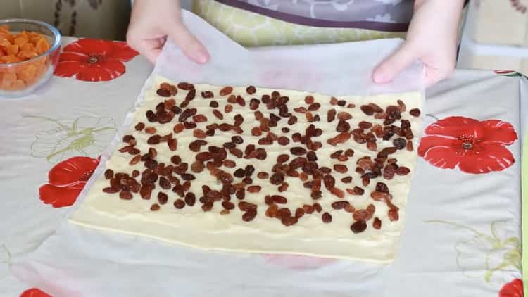 Per fare le lumache di pasta sfoglia, metti l'uvetta sull'impasto