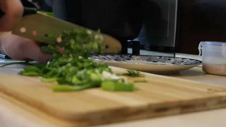 Per preparare la zuppa di salmone, tagliare la cipolla