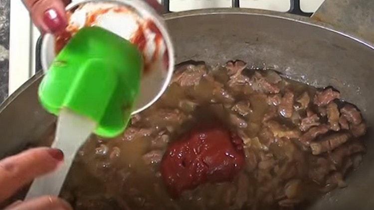 Alla carne con le cipolle aggiungere un cucchiaio di farina e concentrato di pomodoro.