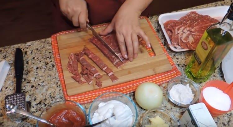 La carne tritata viene tagliata a strisce sottili.