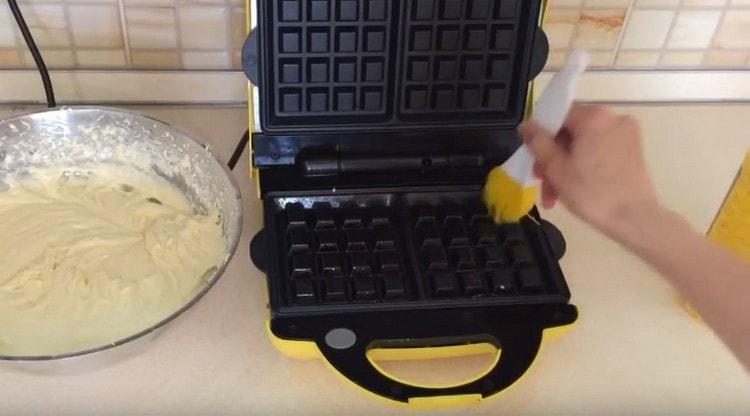 Riscaldiamo il waffle elettrico, ungiamo le forme con olio vegetale.