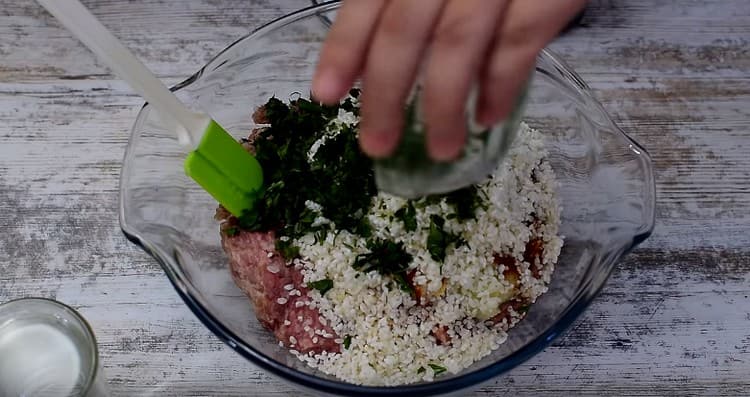 In una ciotola, unisci il riso lavato. carne macinata, cipolle con aglio, prezzemolo tritato e spezie.