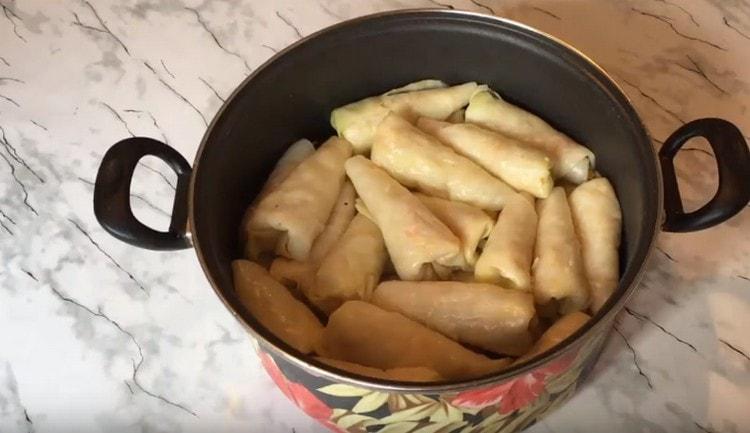 I rotoli di cavolo formati si impilano strettamente in una padella.