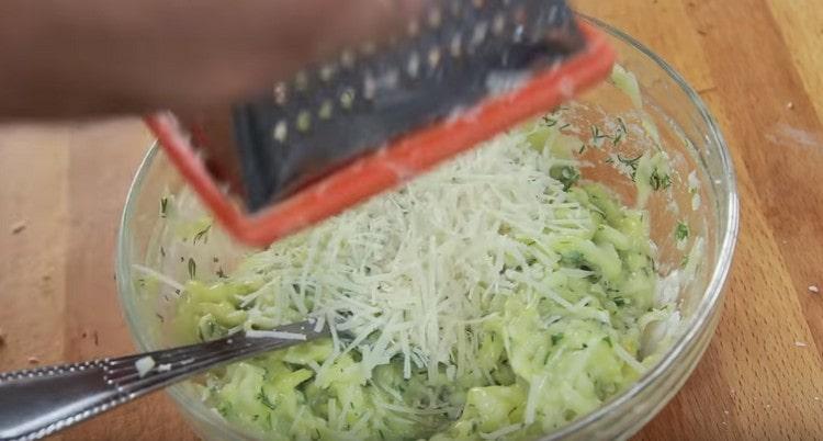 Strofina un po 'di parmigiano nell'impasto di zucchine.