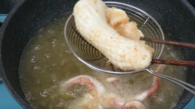 Metti i calamari fritti su tovaglioli di carta.