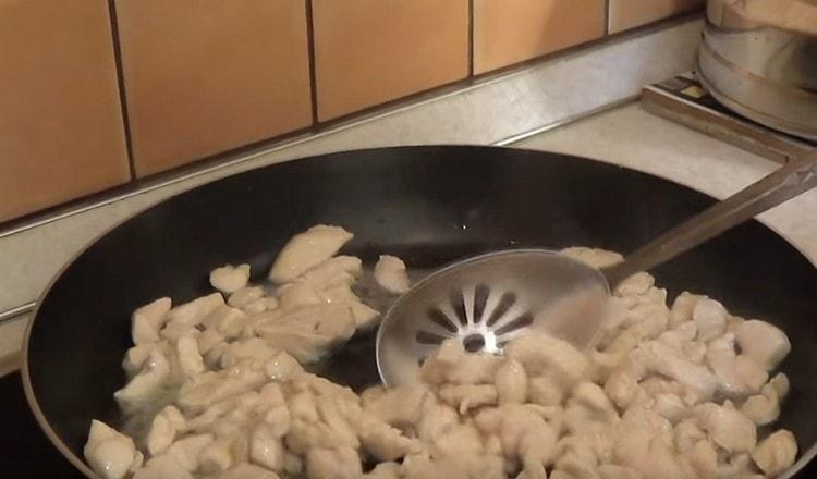 Friggere il pollo in una padella.