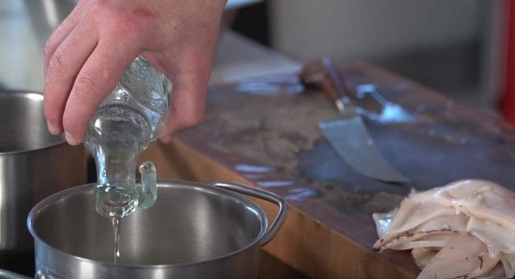 Metti la cipolla in una casseruola, aggiungi l'alloro, i grani di pepe, l'olio vegetale.