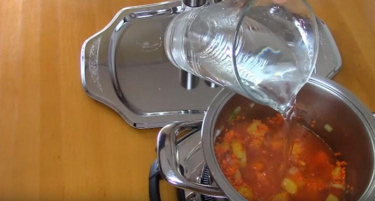 Aggiungi acqua per coprire completamente gli ingredienti nella casseruola.