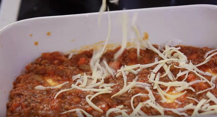 Lo strato successivo è la salsa bolognese e cospargere il tutto con formaggio grattugiato.