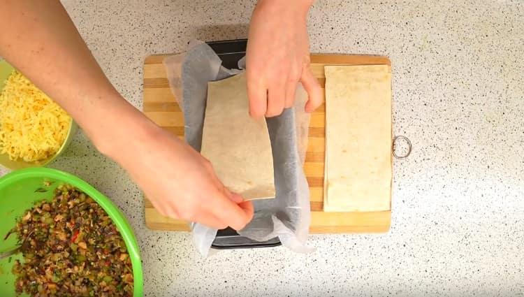 In fondo al modulo stendiamo il primo foglio di pane pita.