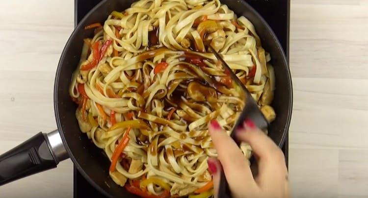 Distribuiamo i noodles alle verdure con il pollo, aggiungiamo la salsa rimanente.