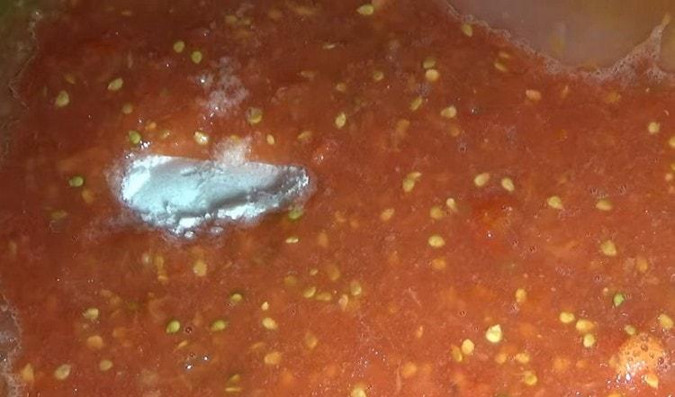 Aggiungi sale e zucchero alla massa di pomodoro.