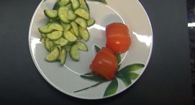 Tagliamo a metà degli anelli un cetriolo e un pomodoro freschi.