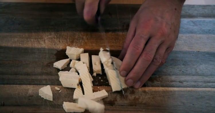 Tagliamo il formaggio feta a cubetti.