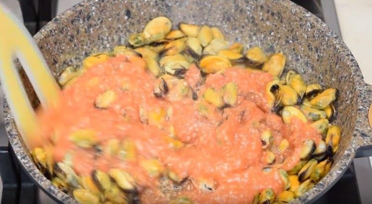 Alle cozze nella padella aggiungere i pomodori tritati in un frullatore con aglio.