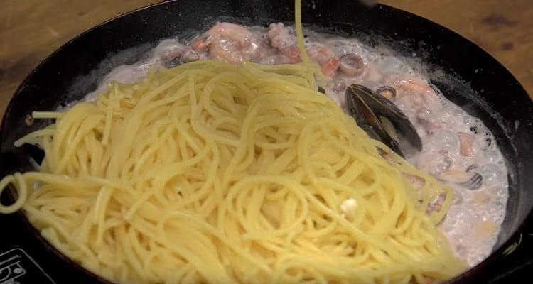 gettiamo la pasta in uno scolapasta e la trasferiamo in una padella di pesce.