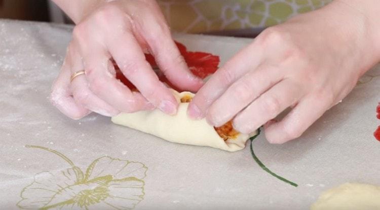 Distribuiamo il ripieno di cavolo su ogni torta e pizzichiamo i bordi.