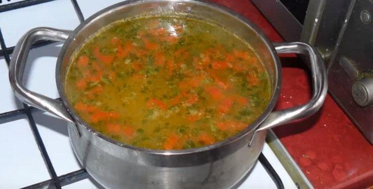 In una zuppa magra quasi pronta con fagioli, aggiungi le verdure tritate.