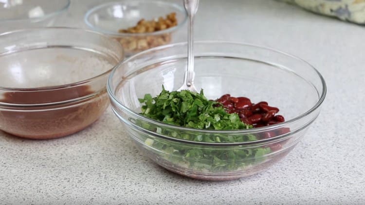 Tritare finemente il coriandolo e aggiungerlo ai fagioli con l'aglio.