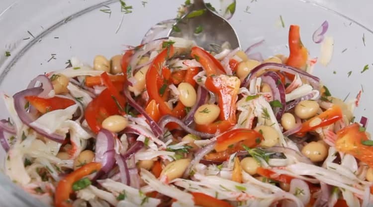 L'insalata profumata con fagioli e bastoncini di granchio è pronta.