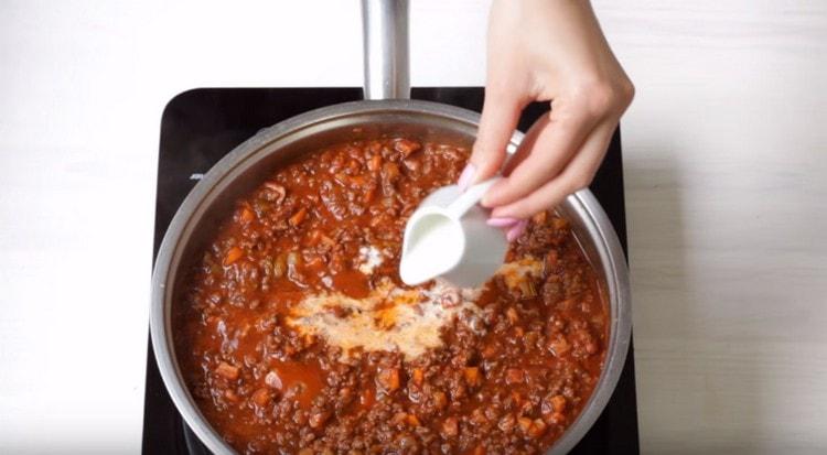 Aggiungi il latte alla salsa in porzioni.