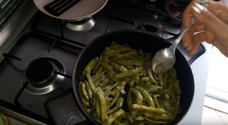 I fagioli vengono aggiunti nella padella alla cipolla, salare e pepare il piatto.