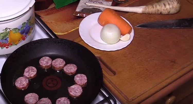 Tagliare la salsiccia affumicata e friggere in una padella.