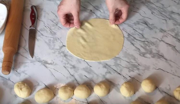 Rotoliamo ogni pezzo di pasta in una torta sottile.