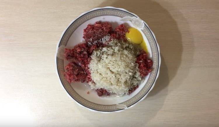 Alla carne macinata, aggiungi riso lavato, cipolle tritate, condimenti.